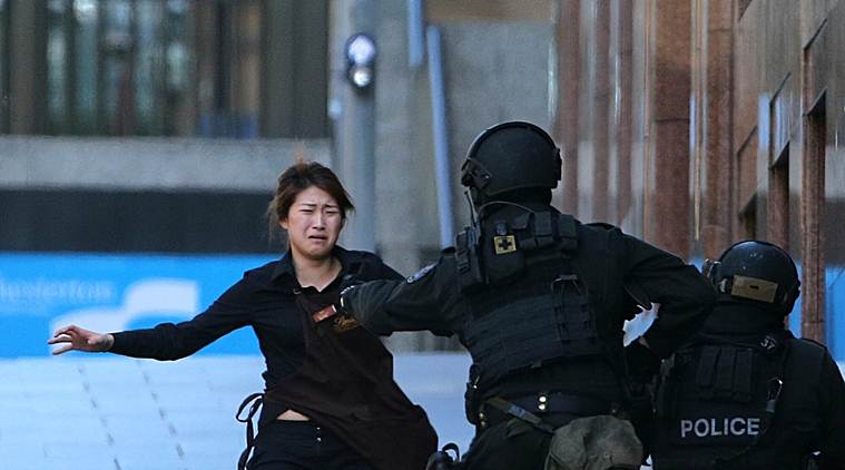 An injured hostage is carried to an ambulance after shots were fired during a cafe siege at Martin Place in the central business district of Sydney, Australia.