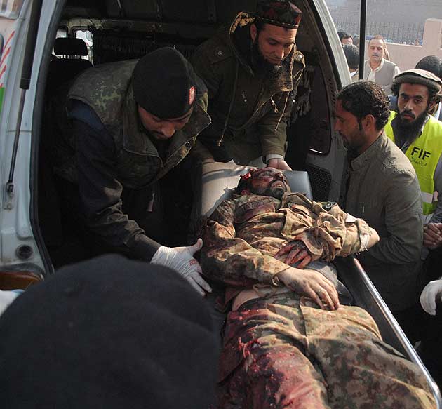 Policemen (L) and civilians move a soldier, who was injured during an attack by Taliban gunmen on the Army Public School, in an ambulance outside a hospital in Peshawar, Pakistan. (Reuters)