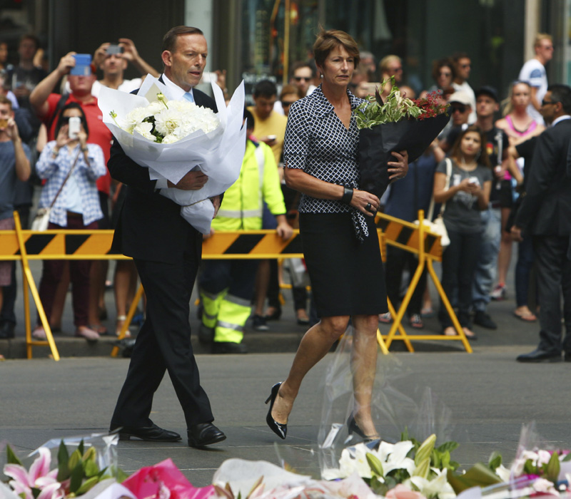 Australian Prime Minister Tony Abbott and his wife Margie arrive to lay flowers in a makeshift memorial for the victims of the siege in Martin Place in Sydney central business district, Australia.