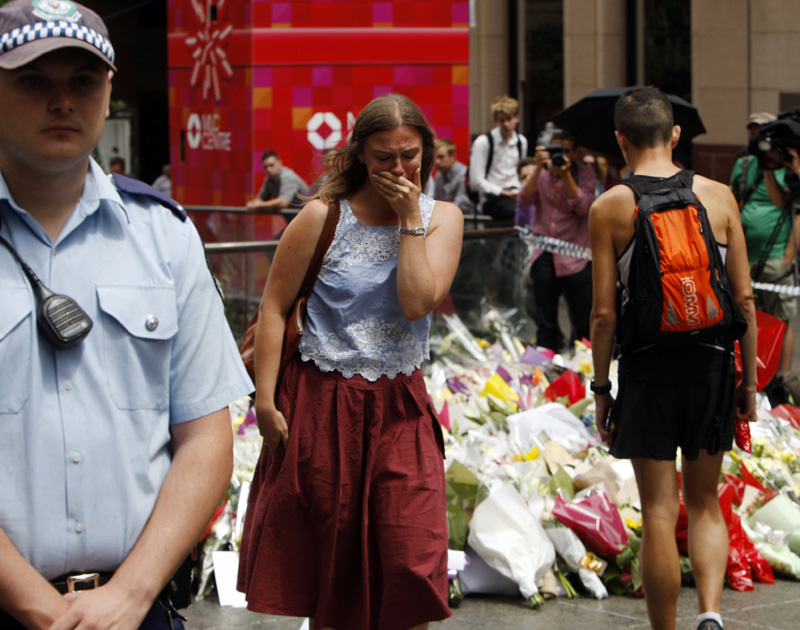 Hundreds of people left flowers at a makeshift memorial in Sydney on Tuesday, Dec. 16, near where three people died in a siege.