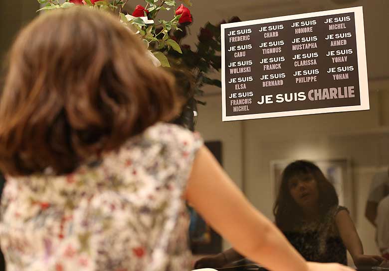 A French girl reads a sign that reads "I am Charlie" as they pay their respects to victims of attacks in Paris on the satirical newspaper "Charlie Hebdo" during a gathering in suburban Makati, south of Manila, Philippines on Wednesday, Jan. 14, 2015. (AP)