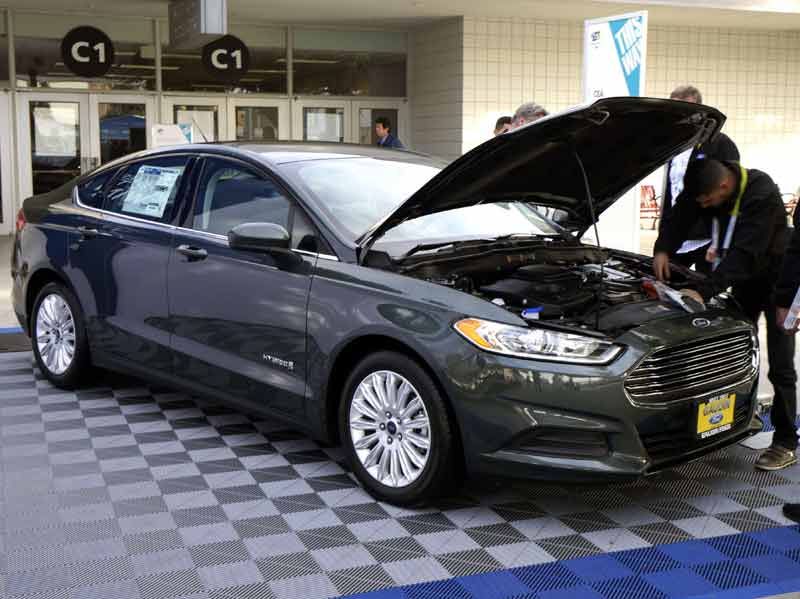 Workers prepare a 2015 Ford Fusion hybrid car for display at the International Consumer Electronics show (CES) in Las Vegas, Nevada. (Reuters)