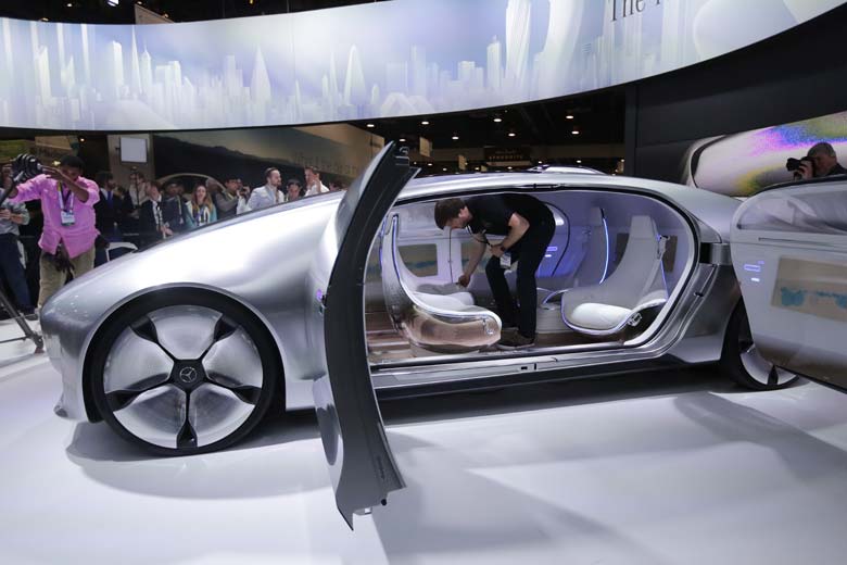 A worker rotates the seats in the self-driving Mercedes-Benz F 015 concept car at the Mercedes-Benz booth at the International CES in Las Vegas. (AP)