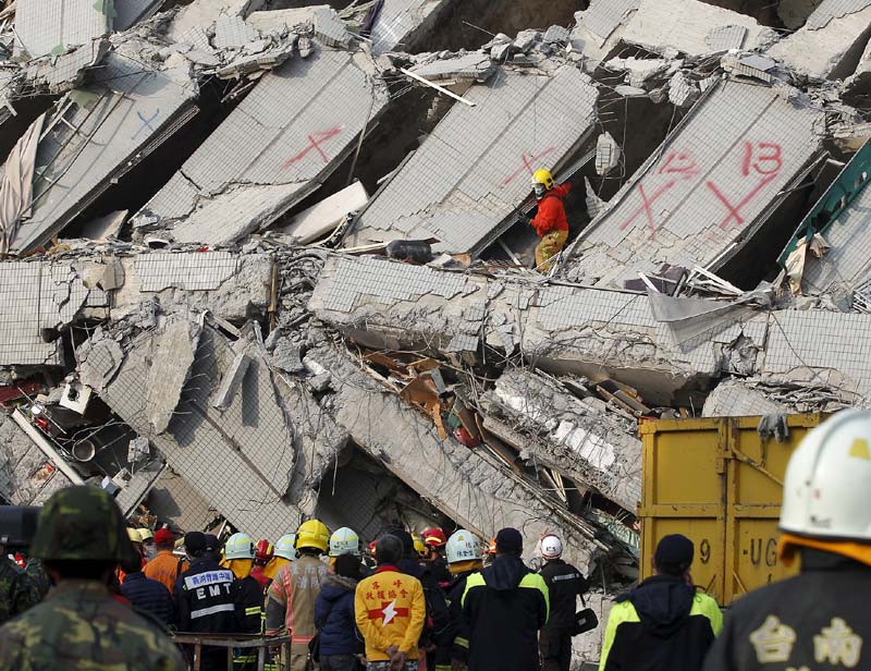 Earthquake in Taiwan: Elsewhere in Tainan, dozens of other people were rescued or safely evacuated from damaged structures or buildings declared unsafe following the quake, including a market and a seven-floor building, authorities said. A bank building also careened, but no one was injured or trapped. All told, nine buildings collapsed and five careened in Tainan, the emergency management information center said. <br>Image Caption: Rescue teams continue to search for the missing in a collapsed building, after an early morning earthquake in Tainan, Taiwan (AP)</br>