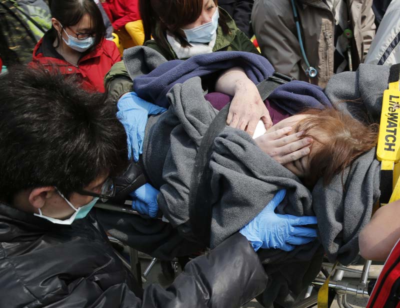 Earthquake in Taiwan: As dawn broke, Taiwanese TV showed survivors being brought gingerly from the high-rise, including an elderly woman in a neck brace and others wrapped in blankets. The trappings of daily life - a partially crushed air conditioner, pieces of a metal balcony, windows - lay twisted in rubble.<br>Image Caption: Rescue teams continue to search for the missing in a collapsed building, after an early morning earthquake in Tainan, Taiwan (AP)</br>