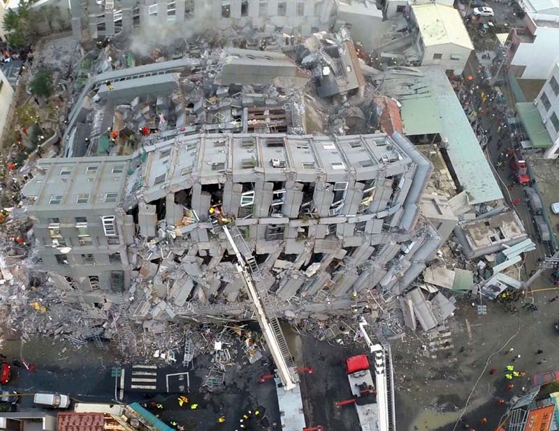 Earthquake in Taiwan: Authorities in Tainan said 12 people were killed, including 11 who were found at the ruins of the fallen building. The national Emergency Management Information center said 477 people were injured, with 380 of them discharged from hospitals by Saturday evening. <br>Image Caption: Rescue workers carry out a man from the site where a 17-storey apartment building collapsed after an earthquake hit Tainan (Reuters)</br>