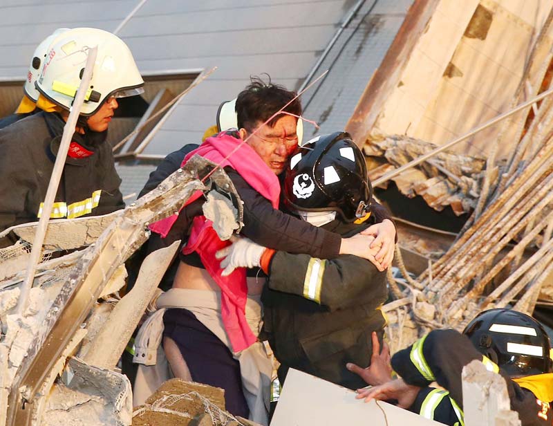 Earthquake in Taiwan: Rescuers pulled out at least 248 survivors from the collapsed building, the emergency management information center said. Throughout Tainan, 337 people were rescued, the city government said. <br>Image Caption: Rescue workers carry out a man from the site where a 17-storey apartment building collapsed after an earthquake hit Tainan (Reuters)</br>
