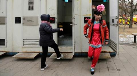 A male folk artist (R) dressed as a traditional Chinese woman walks out of a mobile toilet ahead of a performance at a Spring Festival Temple Fair on the fifth day of the Chinese Lunar New Year at Longtan Park in Beijing. (Reuters)