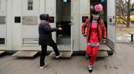 A male folk artist (R) dressed as a traditional Chinese woman walks out of a mobile toilet ahead of a performance at a Spring Festival Temple Fair on the fifth day of the Chinese Lunar New Year at Longtan Park in Beijing. (Reuters)