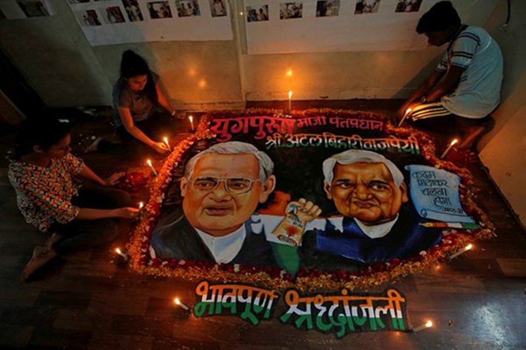 Students place candles around a painting featuring India's former prime minister Atal Bihari Vajpayee to pay him homage in Mumbai, India, August 16, 2018. (REUTERS/Francis Mascarenhas)