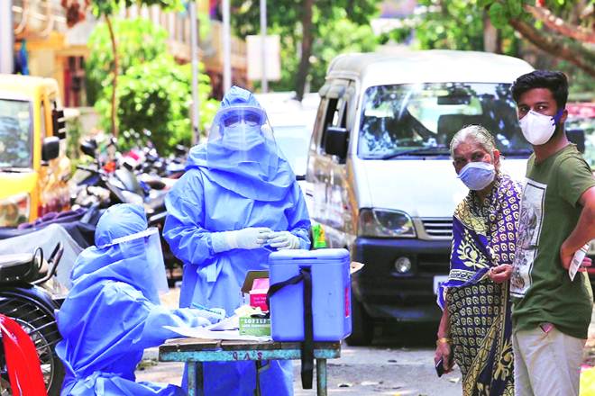 Health workers collect throat swabs for Covid-19 test from residents of a colony in Mahim, Mumbai (Express photo)