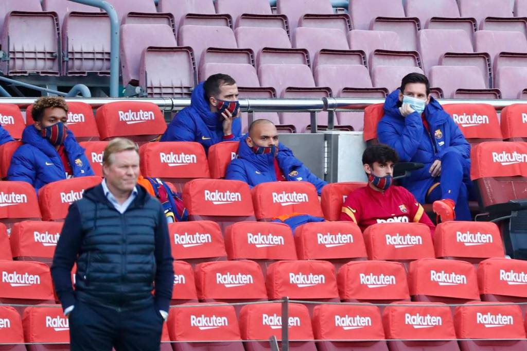 Barcelona's Lionel Messi, right, sits on the bench as Barcelona's head coach Ronald Koeman stands on the side line during the Spanish La Liga soccer match between FC Barcelona and Betis at the Camp Nou stadium in Barcelona, Spain. (AP Photo)