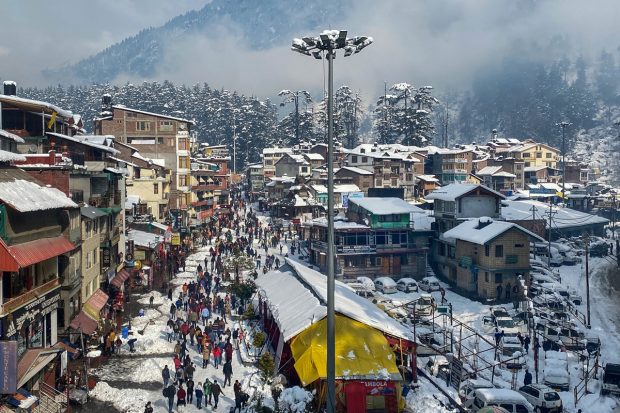 Tourists visit the Mall Road after the weather cleared following snowfall in Manali. (PTI Photo)