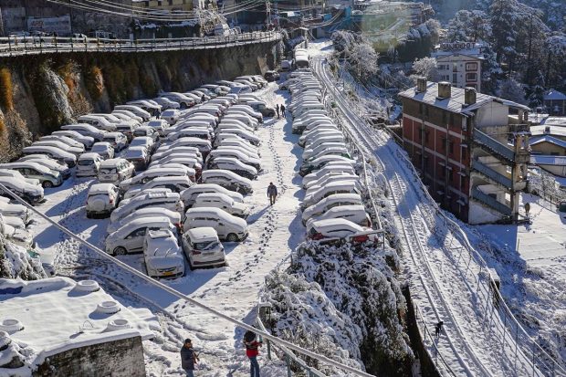 Vehicles covered in snow after heavy snowfall, at a parking area in Shimla. (PTI Photo)