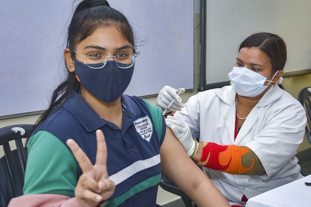 A health worker administers a COVID-19 vaccine to a teenager in Ghaziabad. Vaccination for teenagers between 15 and 18 age group in India began on Monday. (PTI Photo)