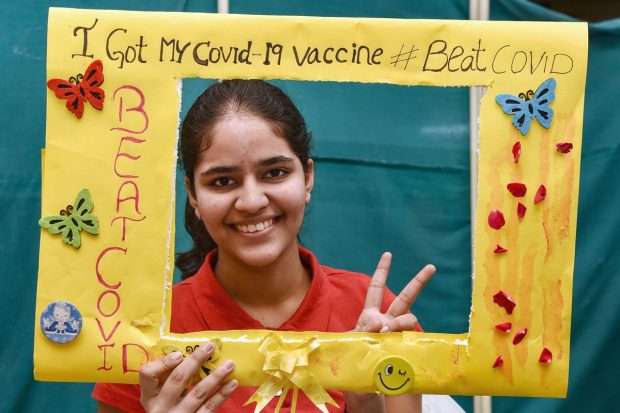 A student poses for photographs after being administered with a COVID-19 vaccine in Hyderabad. (PTI Photo)