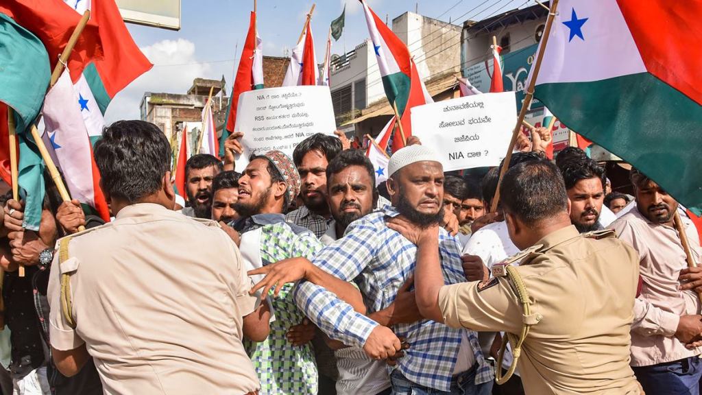 Police attempt to detain PFI and Social Democratic Party of India (SDPI) workers during a protest against NIA raids in Hubballi on Sep 22. (PTI Photo)