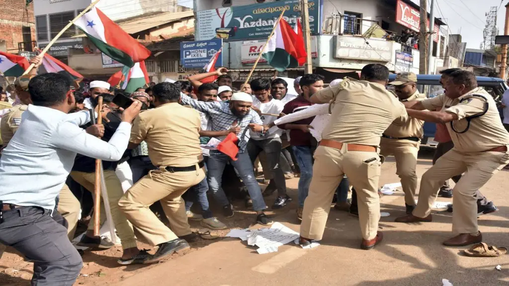 Police attempt to detain PFI and Social Democratic Party of India (SDPI) workers during a protest against NIA raids in Hubballi on Thursday. (PTI Photo)