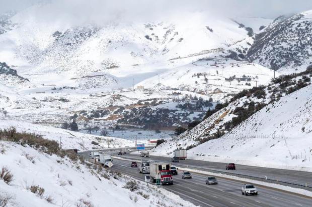 Snow surrounds the I-5 freeway through Gorman, Calif., Monday, Feb. 27, 2023. A winter storm warning is in effect for the area through Wednesday. (David Crane/The Orange County Register via AP)