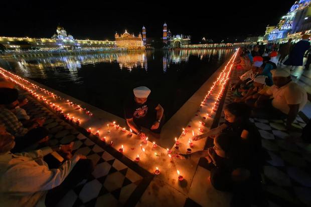 Amritsar: Devotees light earthen lamps during the birth anniversary celebrations of the ninth Sikh Guru, Guru Tegh Bahadur, at Golden Temple in Amritsar, Tuesday, April 11, 2023. (PTI Photo)(PTI04_11_2023_000316B)