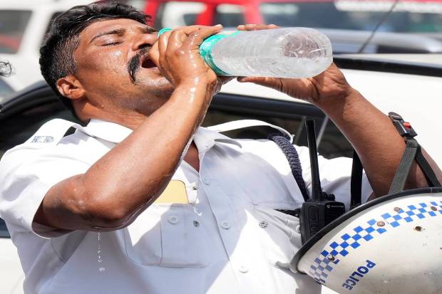 An on-duty traffic police constable quenches his thirst during a hot summer day in Kolkata. (PTI)