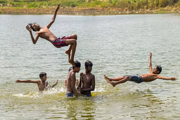 Nadia: Children take a bath to cool off in a pond on a hot summer day, in Nadia. (PTI)