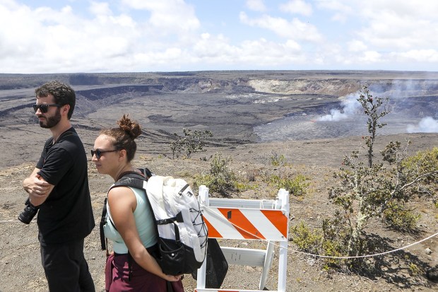 Tourists listen to a tour guide while viewing the Kilauea eruption in Hawaii from an overlook on Wednesday, June 7, 2023. Officials estimated the first day and night of the eruption, June 7 of 2023, brought more than 10,000 people, which is more than triple the number of visitors on a normal day when Kilauea isn't erupting. (Photo: AP)