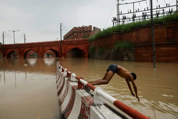 A man dives in a flooded road behind Red Fort, after a rise in the waters of river Yamuna due to heavy monsoon rains, in New Delhi. REUTERS