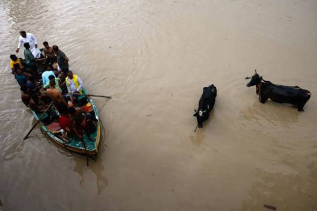 In New Delhi, a boat carrying people moves through a flooded road, after a rise in the waters of river Yamuna due to heavy monsoon rains. REUTERS