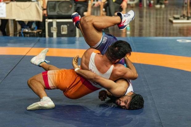 Sandeep (in orange) of SSCB and Saurabh of Uttar Pradesh compete in the men's 60kg category event during the Asian Games 2023 wrestling trials.