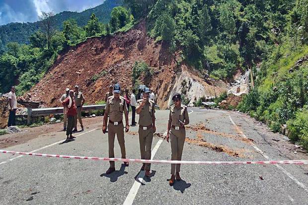 Police personnel at the spot after a portion of the Badrinath national highway washed away due to heavy monsoon rains, near Kameda in Chamoli district. (PTI Photo)