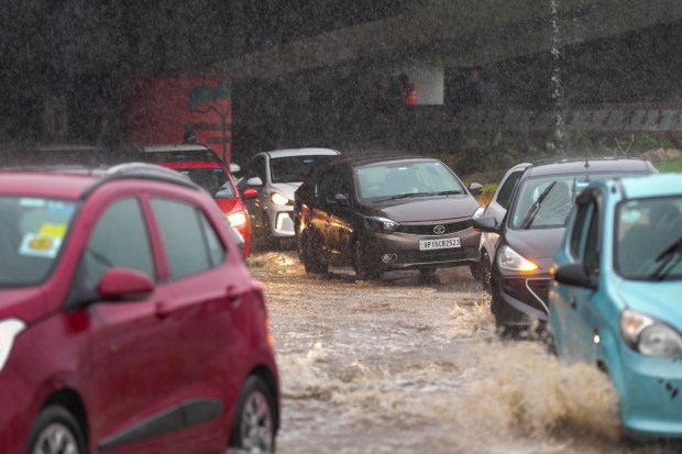 Vehicles move through a waterlogged road. (Image: PTI)