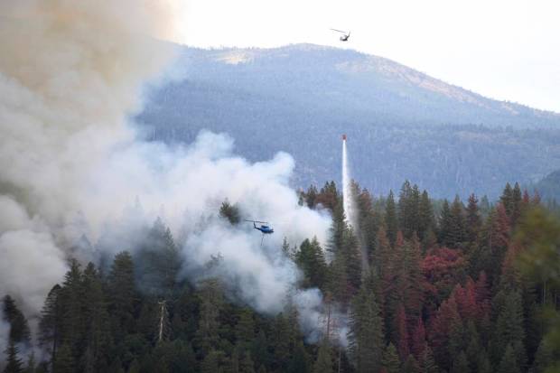 A pair of firefighting helicopters work the Highway Fire near Washington, California. (AP)