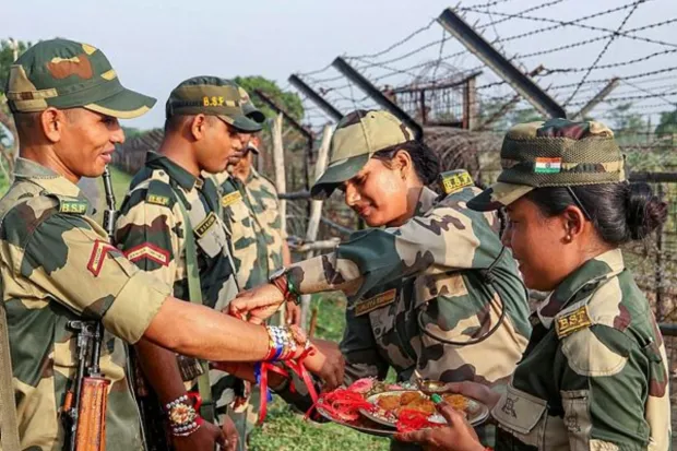 Women constables of the Border Security Force (BSF) tie rakhi to their male colleagues during Raksha Bandhan near the India-Bangladesh border at Dangee in South Dinajpur district. (PTI Photo)