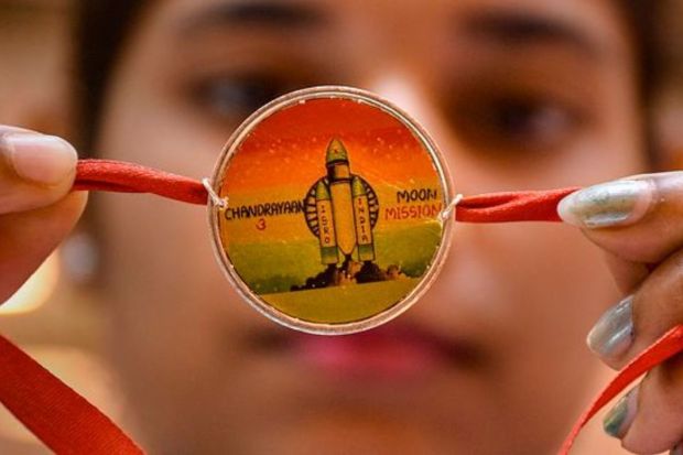 A jeweller shows a 'rakhi' made of a silver coin on the theme of ISRO's Chandrayaan-3 mission in Surat on Thursday. (PTI Photo)