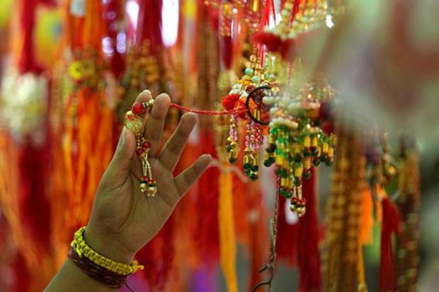 People shop for 'Rakhi', or a sacred thread, ahead of 'Raksha Bandhan' festival in Hyderabad on Monday. (AP Photo)