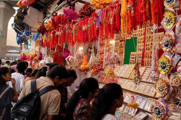 People shop for 'Rakhi', or a sacred thread, ahead of 'Raksha Bandhan' festival in Hyderabad on Monday. (AP Photo)