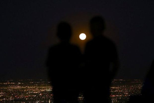 Children watch a super moon, known as the Blue Moon, as it rises above Ciudad Juarez, Mexico. (REUTERS)