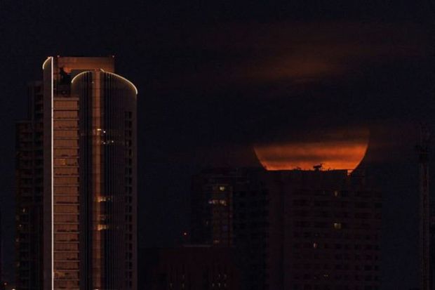 A super moon, known as the Blue Moon, is obscured by clouds as it rises above the city of San Diego, California, U.S., August 30, 2023. (REUTERS/Mike Blake)