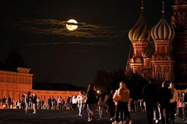 The August Super Blue Moon sets behind a historical building and the St. Basil's Cathedral, right, as people walk in Red Square in Moscow, Russia, Wednesday, Aug. 30, 2023. (AP/PTI)