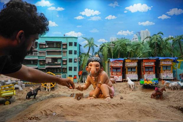 An artist works on a replica of Shivaji Park beach, ahead of 'Ganesh Chaturthi' festival celebrations, at a residential colony in Mumbai. (PTI Photo)