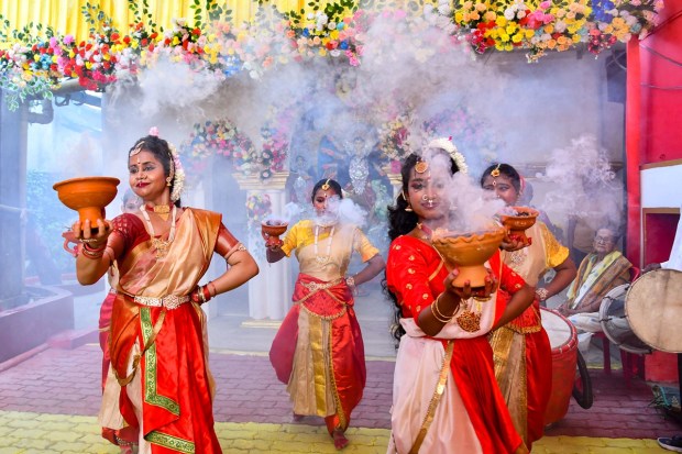 Devotees perform 'Aarti' (traditional Dhunuchi dance) on 'Maha Saptami' of the Durga puja festival at a puja pandal, in Tezpur, Assam. (PTI Photo)