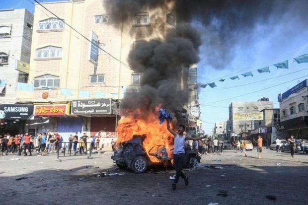 A Palestinian boy reacts next to a burning Israeli vehicle that Palestinian gunmen brought to Gaza after they infiltrated areas of southern Israel, in the northern Gaza Strip. (Image/Reuters)