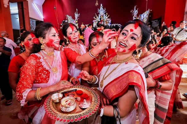 Women apply vermillion on each other as they participate in 'Sindoor Khela' on 'Vijayadashami' in Jaipur (Image: PTI)