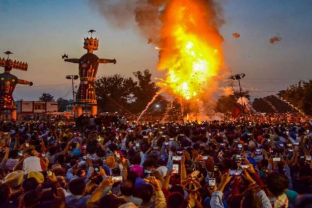 People watch an effigy of Hindu demon king Ravana, Meghanada and Kumbhkaran, stuffed with firecrackers, burning on Dussehra in Amritsar. (Photo: PTI)