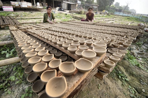 Potters arrange earthen lamps (diya) for drying ahead of the Diwali festival, in Patna. (PTI Photo)