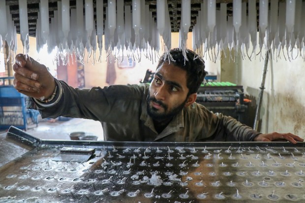 A worker makes candles at a factory ahead of the Diwali festival, on the outskirts of Jammu. (PTI Photo)