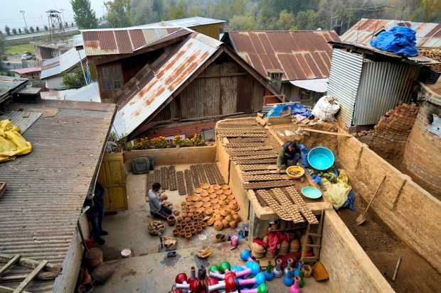 Potter Mohammad Umar with his family makes earthen lamps before Diwali festival at Nishat, in Srinagar. Umar is the only potter of Kashmir Valley who makes earthen lamps occasionally on the festival of lights Diwali for the last two years. (PTI Photo)
