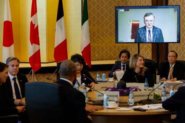 Ukrainian Foreign Minister Dmytro Kuleba is seen on the screen as he remotely joins a session of the Group of 7 Foreign Ministers meetings in Tokyo.(AP Photo)
