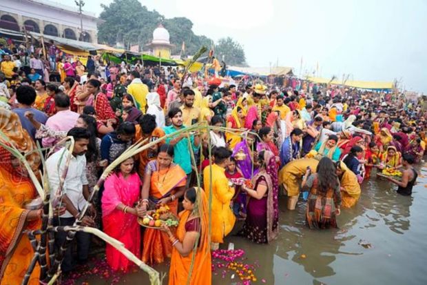 Hindu devotees pray to the Sun god as they stand in knee deep waters in the River Yamuna during Chhath Puja festival in Prayagraj, in the northern state of Uttar Pradesh, India, Sunday, Nov. 19, 2023. During Chhath, an ancient Hindu festival, rituals are performed to thank the Sun god for sustaining life on earth. (AP Photo/Rajesh Kumar Singh)
